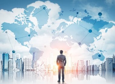 Dal rischio all’opportunità: come le PMI possono crescere in un mercato che cambia. Uomo in abito elegante osserva un panorama urbano con mappa globale sovrapposta, simbolo di connessioni internazionali, reti finanziarie e opportunità di business globali.