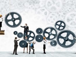 PMI e accesso al credito. Imprenditori e professionisti collaborano per far girare grandi ingranaggi, simbolo del lavoro sinergico tra PMI e consulenti per facilitare l’accesso al credito.