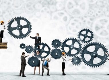 PMI e accesso al credito. Imprenditori e professionisti collaborano per far girare grandi ingranaggi, simbolo del lavoro sinergico tra PMI e consulenti per facilitare l’accesso al credito.