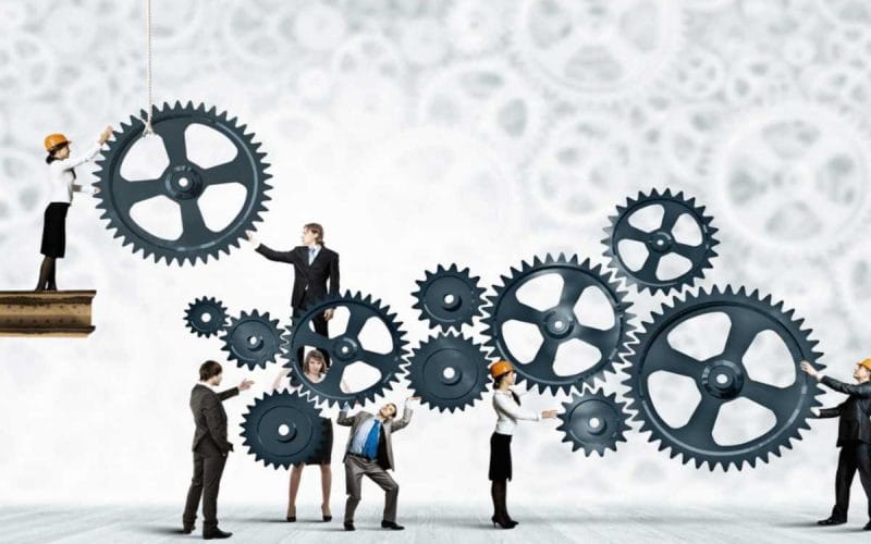 PMI e accesso al credito. Imprenditori e professionisti collaborano per far girare grandi ingranaggi, simbolo del lavoro sinergico tra PMI e consulenti per facilitare l’accesso al credito.