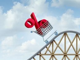 Inflazione, tassi d’interesse e imprese: strategie per navigare la nuova normalità finanziaria. Carrello con simbolo percentuale rosso su una montagna russa, metafora dell’andamento altalenante dei tassi d’interesse e delle dinamiche inflazionistiche per le imprese.