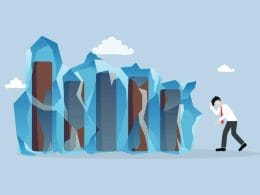 L’economia italiana nel 2025: resilienza o stagnazione? Illustrazione concettuale di un uomo d’affari preoccupato davanti a colonne di dati congelate nel ghiaccio, simbolo di crisi economica, blocco finanziario o stagnazione del business.