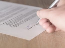 Mutui, prestiti e leasing: tutto quello che devi sapere prima di firmare. Mano che firma un contratto con penna su un foglio ufficiale: simbolo della decisione consapevole su mutuo, prestito o leasing.