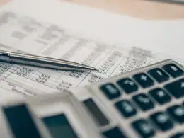 Periodi mancanti nell’estratto conto contributivo: quali strumenti ha a disposizione il lavoratore per tutelare i propri diritti pensionistici? Primo piano su calcolatrice e penna posate su un foglio con dati contributivi: simbolo dell’analisi dei periodi mancanti nell’estratto conto previdenziale INPS.