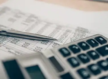 Periodi mancanti nell’estratto conto contributivo: quali strumenti ha a disposizione il lavoratore per tutelare i propri diritti pensionistici? Primo piano su calcolatrice e penna posate su un foglio con dati contributivi: simbolo dell’analisi dei periodi mancanti nell’estratto conto previdenziale INPS.