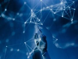 Insurtech e instant insurance: la rivoluzione delle polizze a portata di clic. Mano robotica che interagisce con una rete di connessioni digitali in un ambiente futuristico blu, simbolo di intelligenza artificiale, algoritmi e tecnologia avanzata.