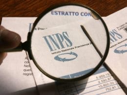 Gestione Commercianti INPS: contributi versati e sorprese in fase di pensionamento. Documento INPS con logo messo a fuoco da una lente d’ingrandimento: analisi dell’estratto conto contributivo per il calcolo della pensione.