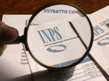 Gestione Commercianti INPS: contributi versati e sorprese in fase di pensionamento. Documento INPS con logo messo a fuoco da una lente d’ingrandimento: analisi dell’estratto conto contributivo per il calcolo della pensione.