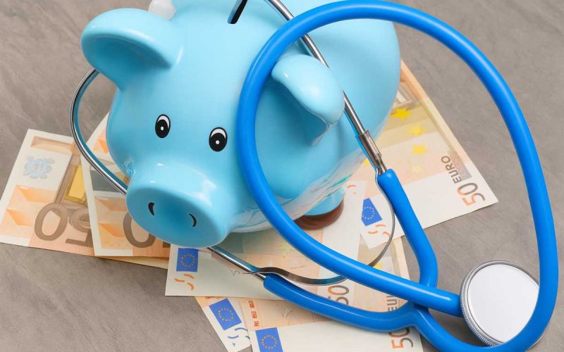 Spesa sanitaria e risparmio: concetto illustrato con salvadanaio e stetoscopio