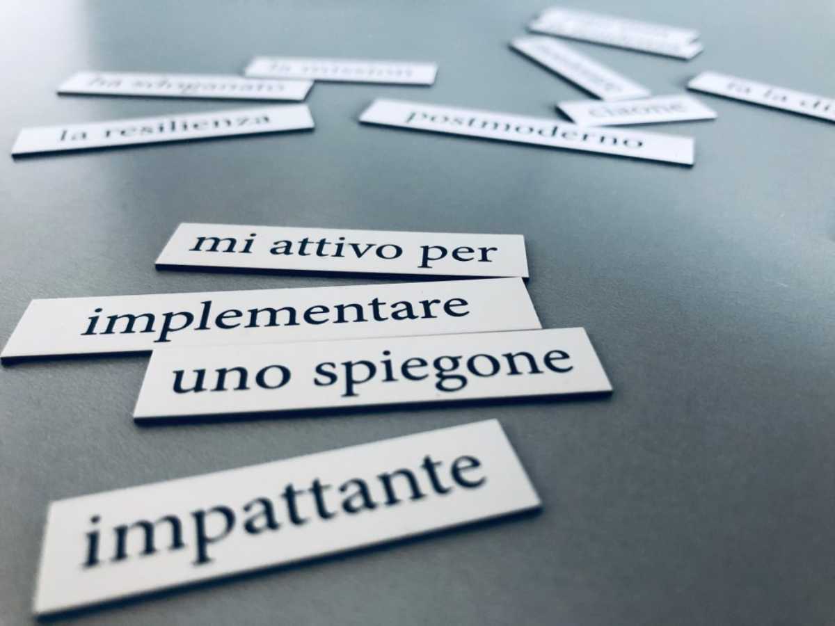 Frasi tipiche dell’aziendalese scritte su cartoncini bianchi disposti su un tavolo grigio