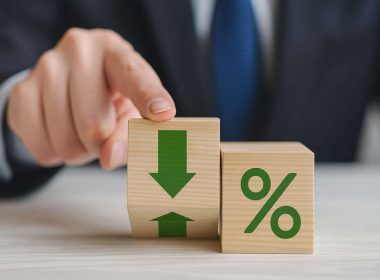 Il rating bancario: mano maschile in giacca e cravatta che indica blocchi di legno con simboli di percentuale e frecce
