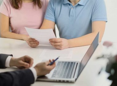 Negoziare meglio con la banca – coppia e consulente durante trattativa su documenti. Coppia che negozia con la banca tenendo documenti davanti a un consulente