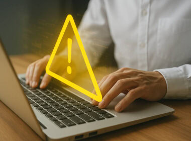 Persona al computer con simbolo di allerta per polizze fidejussorie fraudolente