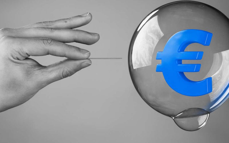 Mano con spillo pronta a far scoppiare una bolla con simbolo dell’euro blu, metafora delle bolle speculative nel mercato dell’arte da Van Gogh a Damien Hirst.