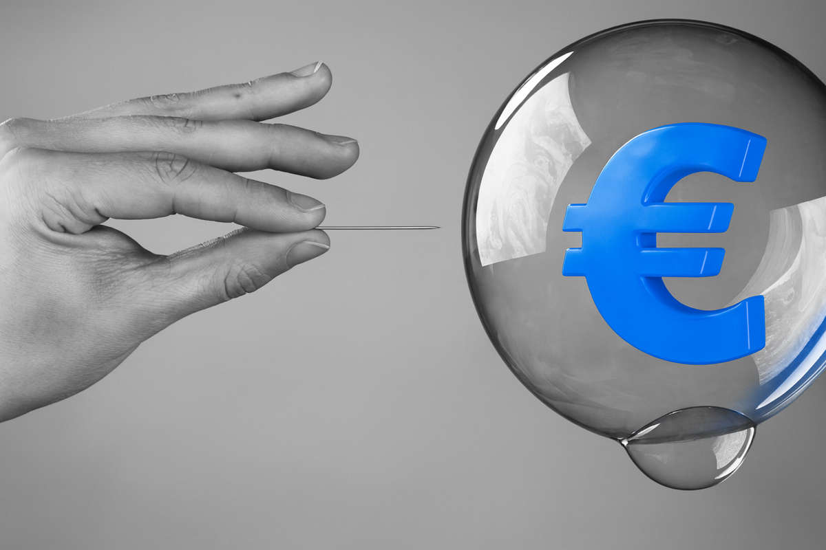 Mano con spillo pronta a far scoppiare una bolla con simbolo dell’euro blu, metafora delle bolle speculative nel mercato dell’arte da Van Gogh a Damien Hirst.