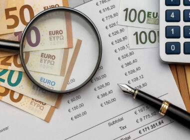 Costi conto corrente: euro, calcolatrice, lente e fattura in primo piano