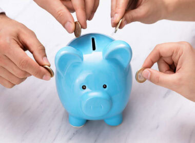 Persone che inseriscono monete in un salvadanaio azzurro, simbolo di lending crowdfunding