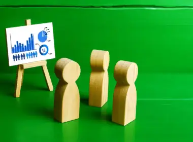mese dell'educazione finanziaria con figure in legno davanti a un grafico su cavalletto