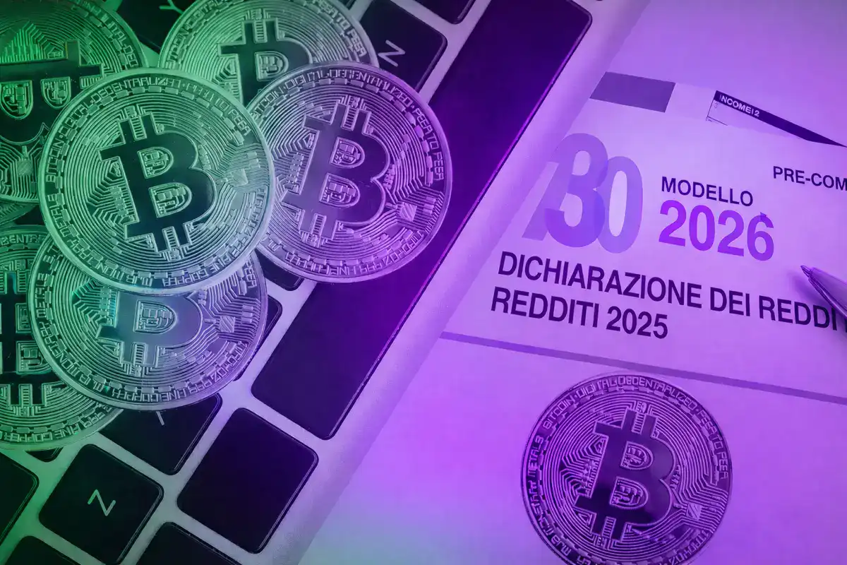 Criptovalute e dichiarazione dei redditi 2026: bitcoin su tastiera accanto al modello fiscale 2025, simbolo dell’impatto della normativa DAC8 sulla fiscalità crypto.