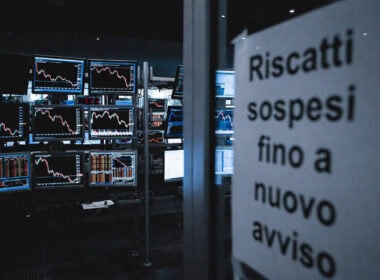 Fondi di private credit: sala trading con monitor in rosso e cartello "Riscatti sospesi fino a nuovo avviso"