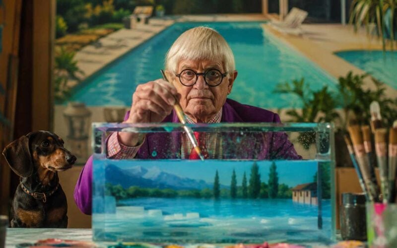 morte di David Hockney, artista anziano con bassotto mentre dipinge una scena acquatica in uno studio creativo