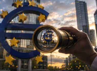 Il credito non manca. Sta cambiando destinatario: quali imprese finanzieranno le banche nel secondo semestre 2026. Credito alle imprese 2026, osservazione del simbolo dell’euro davanti a un distretto finanziario moderno