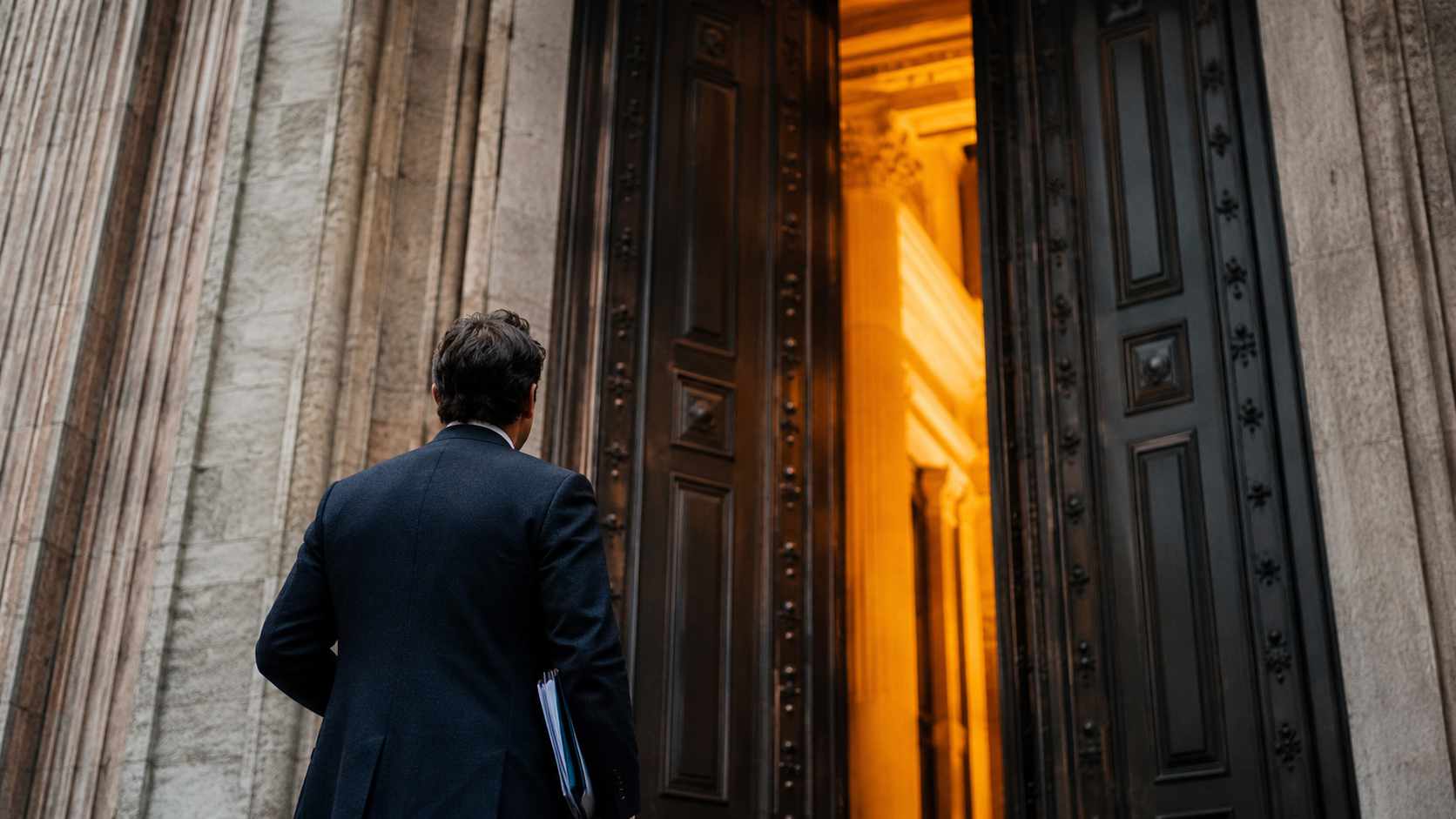 Finanziamenti PMI 2026: guida completa agli incentivi. Finanziamenti agevolati PMI 2026, imprenditore davanti all’ingresso di una banca prima di richiedere credito per investimenti