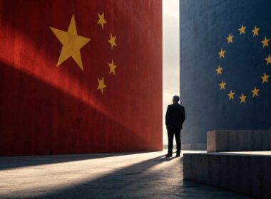 Uomo tra una parete rossa con stelle cinesi e una blu con stelle dell’UE, simbolo visivo della rivalità sistemica.